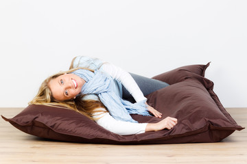 junge frau wühlt sich in ein sitzkissen