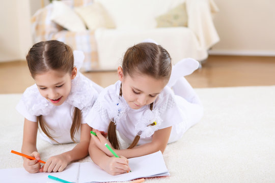 twin sisters together at home with books