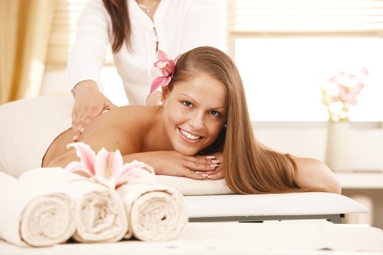 Happy young woman enjoying back massage