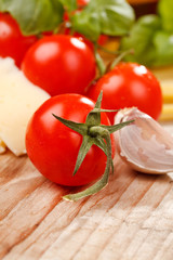 pasta, olive oil and tomatoes on the wood background