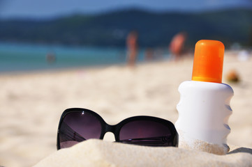 Sunglasses and sun lotion on the beach