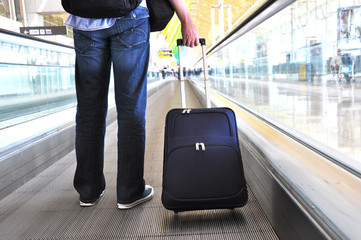 Traveler with a suitcase on the speedwalk