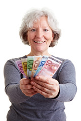 Seniorin hält Geldscheine