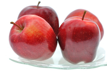 czerowne soczyste jabłka na szklanym talerzu