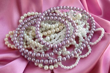 pearl necklaces on pink satin