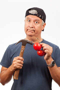 Middle Age Man Hammering a Tomato