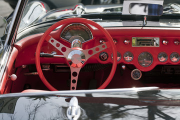 Red dashboard and steering wheel of classic car