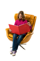 preteen girl sitting in a chair reading a book