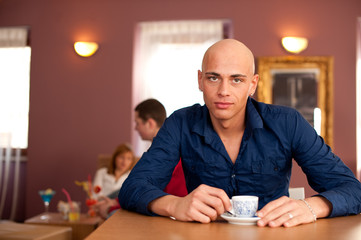 Young man drinking coffee in cafe