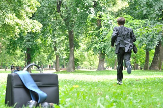 Business man running in park - escape