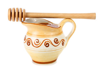 honey in a jug and wooden stick
