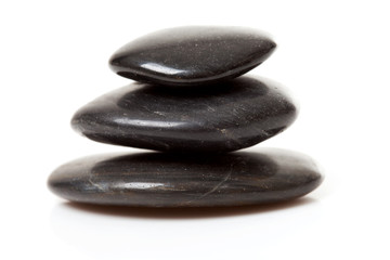 pile of three black pebbles over white background