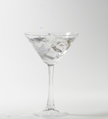 martini cocktail splashing into glass