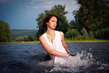 Young beautiful  woman on a river