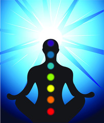Male silhouette meditating with chakra
