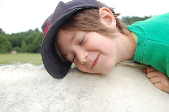 petite fille faisant un calin au cheval