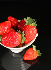 Strawberry in cup on black