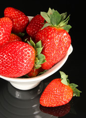 Strawberry in cup on black