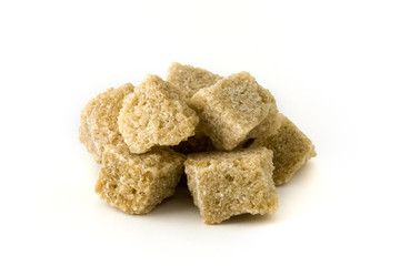 Pile of brown sugar cubes over white