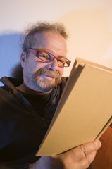 grinning man behind book