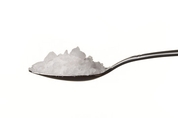 Rock salt in a spoon isolated over white background