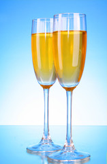 Glass with champagne on blue background