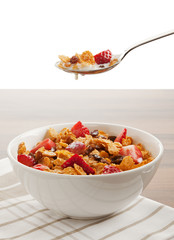 cereals and fruit with milk in bowl and on spoon