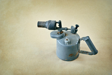 Old blowtorch on a paper sand