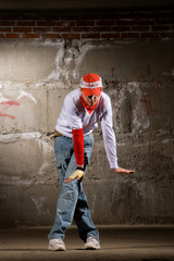 Fototapeta premium Hip hop boy dancing in modern style over grey brick wall