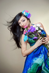 Fototapeta premium Beautiful young woman with colorful flowers in hair
