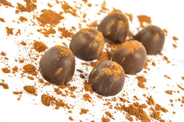 Chocolates sprinkled with cocoa, isolated on a white background