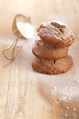 soft ginger cookies three stacked and dusted on wooden table