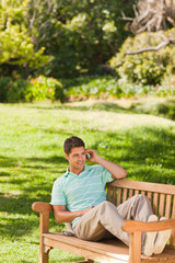 Man with his phone on the bench