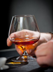 Hand with glass of cognac