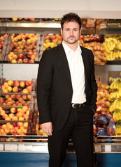 Junger Mann mit Anzug im Supermarkt