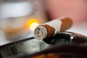 Burning cigar in ashtray
