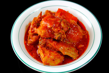 bowl of spicy chicken with black background