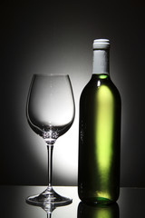 Bottle of white wine and empty wine glass