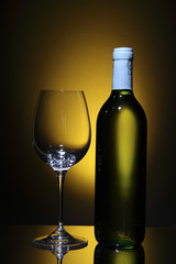 Bottle of white wine and empty wine glass