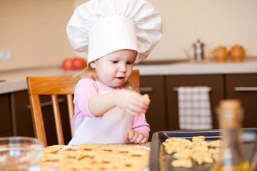 Little girl preparing cookies on kitchen