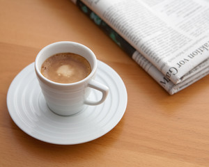 Tasse Espresso mit Zeitung auf dem Tisch