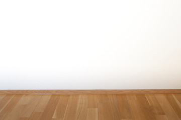 Parket und weiße Wand in einem leeren Zimmer