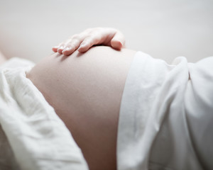 schwangere Frau mit Hand auf ihrem Bauch