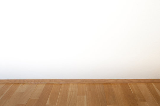 Parket und wei&szlig;e Wand in einem leeren Zimmer