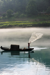 Fisherman casting net on river