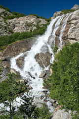 Mountain waterfall with clear blue water