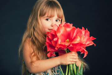 Obraz na płótnie Canvas little girl with tulips bouquet
