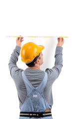 Construction worker measuring the wall over white background.