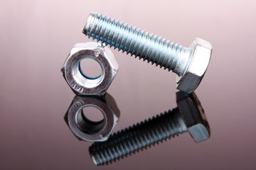Screw and bolt with reflection on grey background