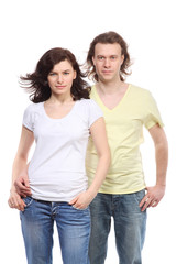 Portrait of young couple in jeans, serious boy embraces girl